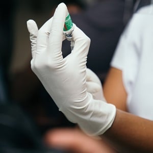 Woman receives an updated records book for her 6 months old daughter after being vaccinated at the community clinic.